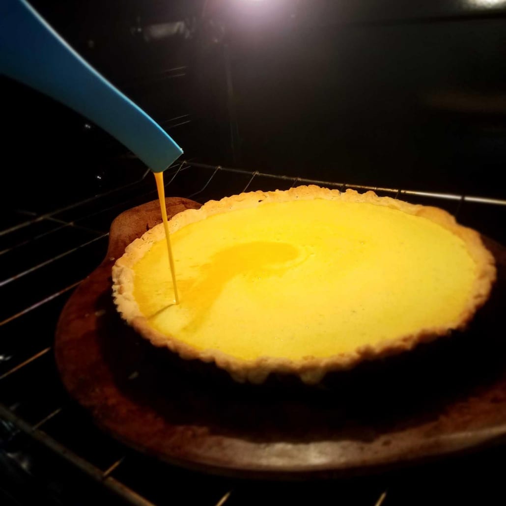 Add the lemon ginger turmeric filling to the tart while it is in the oven.