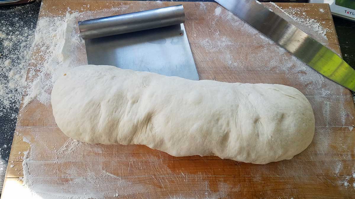 Shaping dough into a cuban bread loaf.