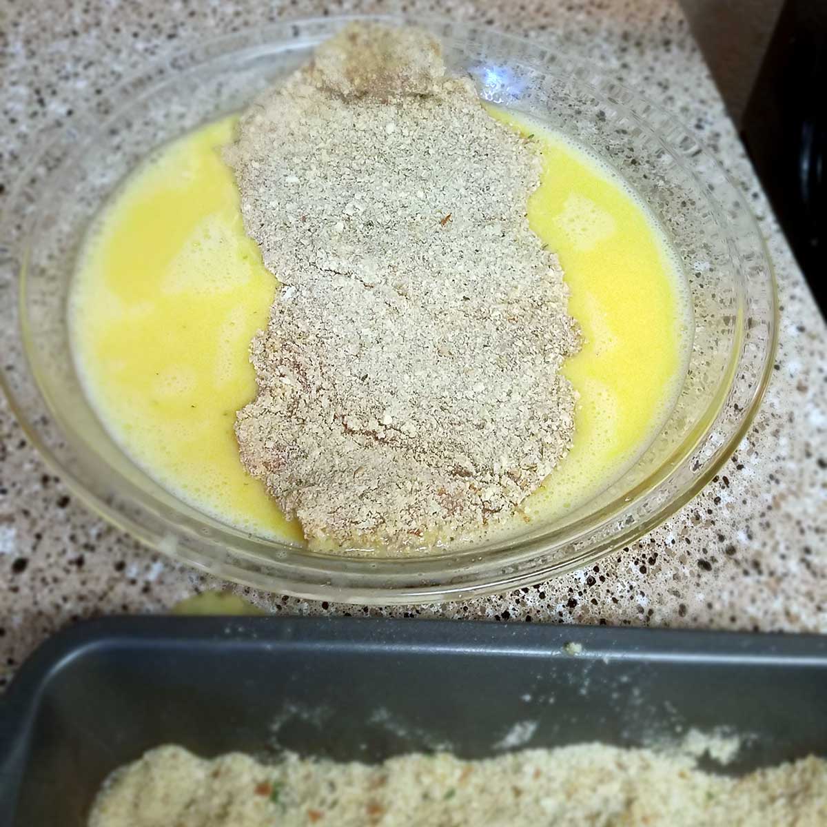Schnitzel goes into egg wash